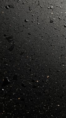 black wet surface with rain drops on black background.