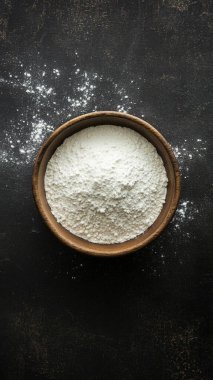 Siyah arka planda bir kase un.