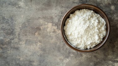 Bir kase çiğ pirinç. Masada un var.