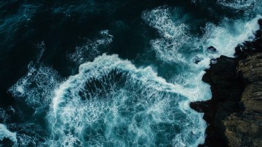 Dalgalar kayalık kıyılara çarpıyor