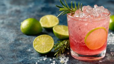 Koyu renkli masada limonlu ve naneli bir bardak soğuk içecek.