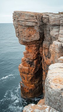 Bulutlu bir günde kayalık bir karadaki kayalık kayalıkların dikey görüntüsü.