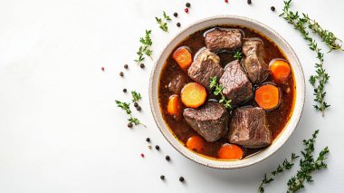 Sebzeli sığır güveci ve beyaz ahşap bir tabakta baharatlar.