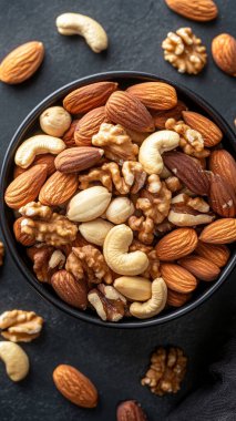 Ahşap masada bir kase fındık ve kurutulmuş kayısı kompozisyonu. en üstteki görünüm.