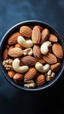 Siyah masada fındıkları kaseye karıştır. Sağlıklı yemek, diyet ve atıştırmalık konsepti. Üst görünüm, boşluk kopyala