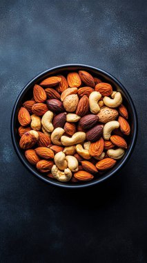 Bir kase karışık fındık, bademli ve fındıklı, siyah arka planda.