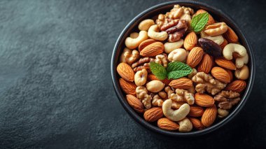 Arka planda farklı tipte cevizler olan bir kase. Üst Manzara. Metnin için boş yer.