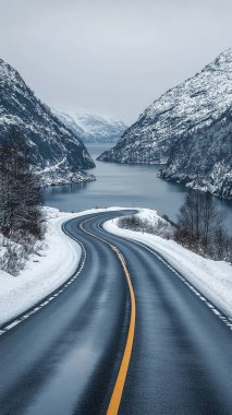 Boş asfalt yolu kış boyunca karla kaplı dağlar, Norveç