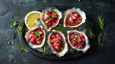 Baharatlı ve limonlu çiğ kırmızı balık filetosu ve siyah taş masa. en üstteki görünüm.