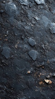 Çatlaklı siyah taş bir duvarın koyu dokusu.