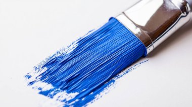 Beyaz arkaplanda fırça darbesi olan mavi boya fırçası