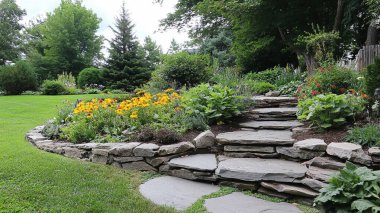 Büyük bir taş ve büyük bir duvarı olan güzel bir bahçe.