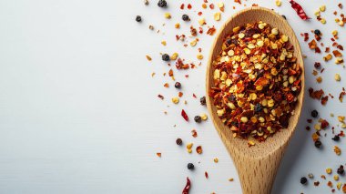 Tahta bir tabakta baharatlarla kaşıkta kırmızı mercimek manzarası.