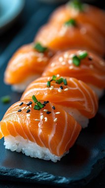 Çiğ somon suşisi, pilav, suşi, somon balığı, sashimi, soya sosu ve siyah tabakta soya sosu.