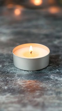 Gri mermer arka planda yanan alevli mum, yakın plan. Metin için boşluk