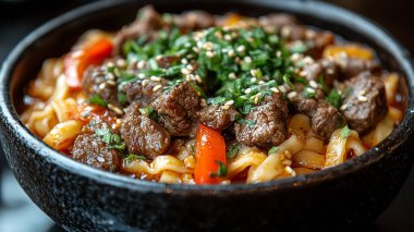 Bir kase lezzetli makarna ve masada et.