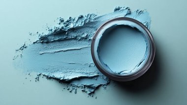 Mavi arka planda fırçası olan cam bir kapta kozmetik krem.