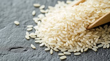 Beyaz pirinç ve ahşap kasede pişmemiş pirinç.