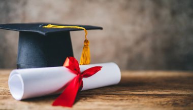 Mezuniyet şapkası, diploma ve diploma tahta masada. Metin için boşluk