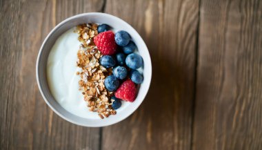Yoğurtlu sağlıklı kahvaltı, taze yaban mersini, ahududu ve müsli.