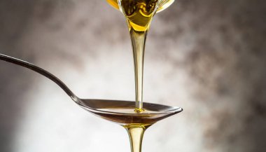 Cam kavanoz bal, ahşap masada kaşık ve kepçeyle.