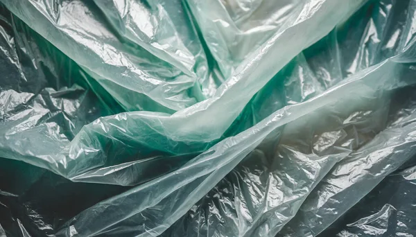 Gri arka planda yeşil plastik çöp torbası. ekoloji kavramı.