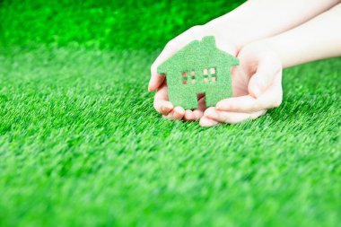 Bir adam elinde bir eko-ev tutuyor..