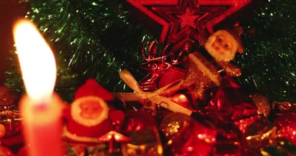 Decoración festiva de Navidad con una vela encendida. Celebración de Año Nuevo, tiempo de vacaciones. Árbol de Navidad, Caja de regalo de Navidad, bola. — Vídeo de stock