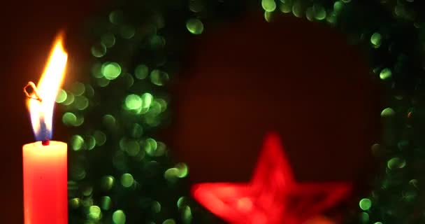 Decoración festiva de Navidad con una vela encendida. Una sola vela aislada se enciende con un fondo bokeh abstracto oscuro. Celebración de Año Nuevo, Tiempo de vacaciones. — Vídeo de stock