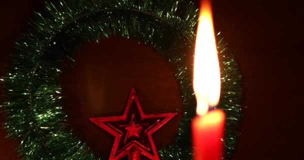Новорічні та різдвяні прикраси інтер'єру. зміна фокусу різдвяної зірки на червоні свічки освітлена темним абстрактним фоном боке — стокове відео