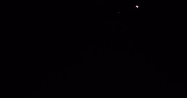 Renkli bayram havai fişekleri arka planı. Gece gökyüzünde bokeh ışıkları olan gerçek altın sarısı havai fişeklerin soyut bulanıklığı. Parlak havai fişek gösterisi. Yeni yıl arifesi gerçek havai fişek kutlaması.