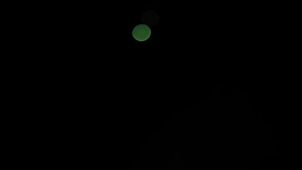 Abstraktes schönes glitzerndes Bokeh vor dunklem, verschwommenem Hintergrund in der Nacht. Das runde bunte Bokeh leuchtet vom Feuerwerk am dunklen Himmel. — Stockvideo