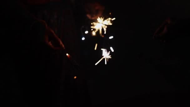 Mano de cerca sosteniendo petardos, gente celebrando fiesta nocturna con fuegos artificiales en la mano. Ideal para todas las celebraciones del festival Navidad, Año Nuevo, Diwali, y muchos más. — Vídeos de Stock