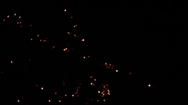 Fondo colorido fuegos artificiales de vacaciones. La víspera de Año Nuevo es una verdadera celebración de fuegos artificiales. Brillantes galletas doradas brillantes con luces bokeh en el cielo nocturno. Espectáculo de fuegos artificiales brillantes. — Vídeos de Stock