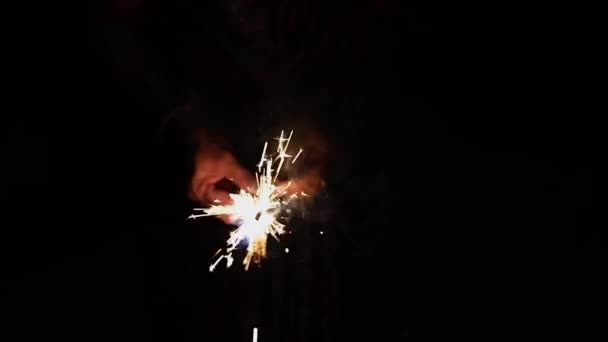 Femme tenant des étincelles brûlantes dans sa main sur fond sombre, Noël et Nouvel An fête étincelante, Nouvel An 2020 — Video