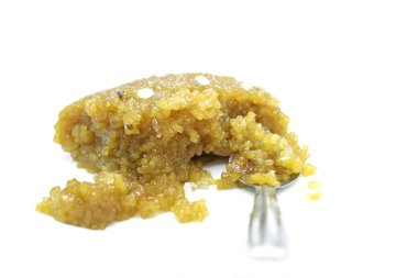 Beyaz arka planda tatlı pongallı gümüş kaşık.