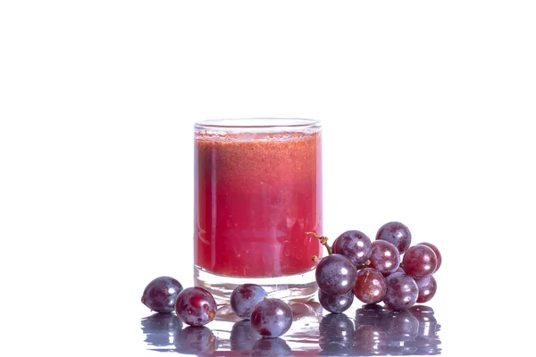 酒杯中的红葡萄酒汁和白色背景下分离的葡萄果实 — 图库照片