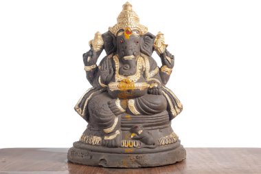Altın madalyalı gri taş Ganesha heykeli, birçok kolla oturmuş, bilgeliği ve refahı simgeliyor..