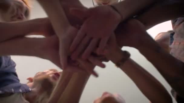 Below shot of group of millennials cheer with their hands together in the center — Stock Video