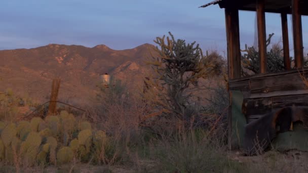 Tanque de agua y casa abandonada en el desierto durante el atardecer / amanecer dolly shot — Vídeos de Stock