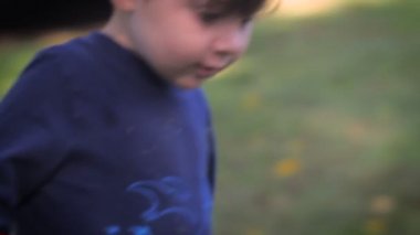 Gülümseyen ve yürüyen küçük bir çocuğun el yapımı yavaş çekim portresi