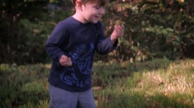 Güzel bir genç çocuk bir şey alır, gülümsüyor ve kameraya doğru yürür.