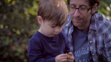 Father and son playing and exploring together while boy walks away