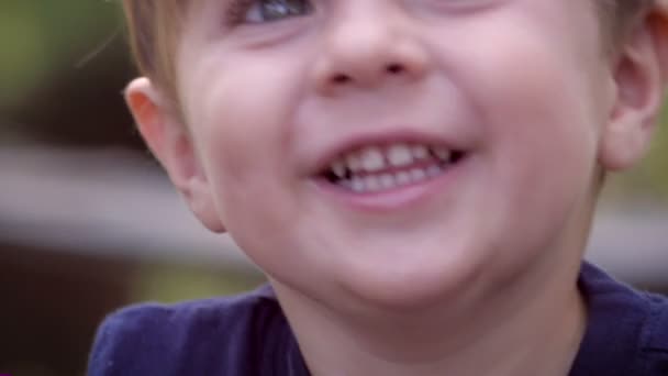 Hand held close-up portret van een jonge lachende schattige gezonde jongen — Stockvideo