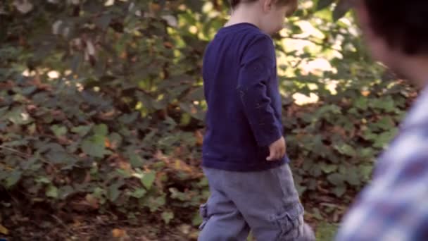 Een vader kijken naar zijn jonge zoon lopen door en dan krijgt hij op — Stockvideo