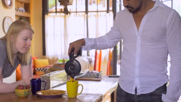 Unga interracial par kyssa på morgonen efter mannen förbereder frukost — Stockvideo
