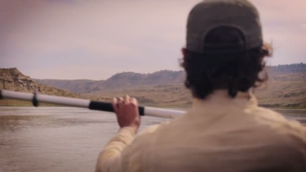 Man peddelen over de Missouri-rivier in Montana dragen van een honkbal hoed — Stockvideo