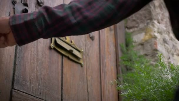 Χαμηλή γωνία ενός άντρα που ανοίγει μια ξύλινη πόρτα αντίκα — Αρχείο Βίντεο