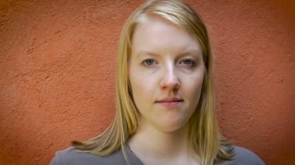 Porträt einer attraktiven jungen blonden Frau um die 20, die in die Kamera lächelt — Stockvideo