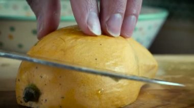 Bir bıçak ile taze sulu mango dilimleme bir el yakın